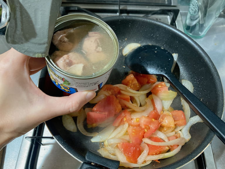 玉ねぎがしんなりしてきたらトマトを加えて炒め、サバ缶を汁ごと加えて崩しながら全体を混ぜ合わせる